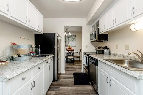 a kitchen with white cabinets and a black refrigerator