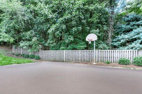 a court with a basketball hoop and a fence
