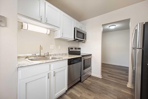 a kitchen with white cabinets and stainless steel appliances