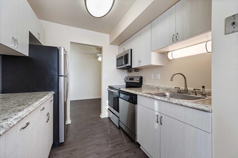 a kitchen with white cabinets and a sink and a refrigerator