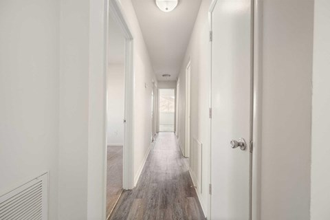 a renovated hallway with white walls and wood floors