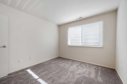 a bedroom with carpet and a window