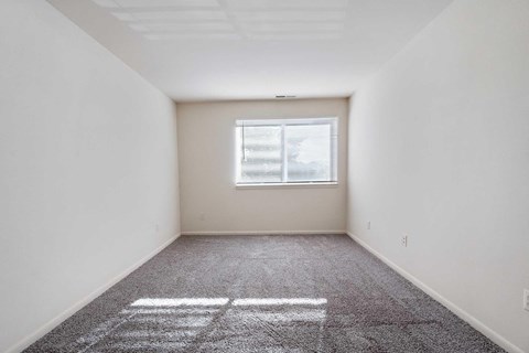 an empty room with white walls and a window