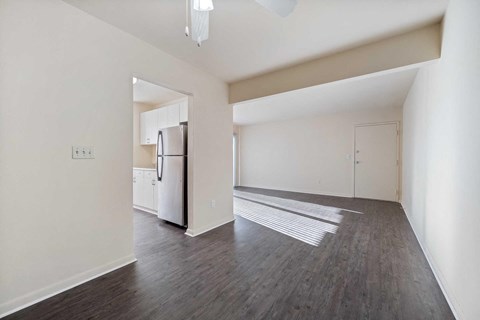 an empty living room with a refrigerator and