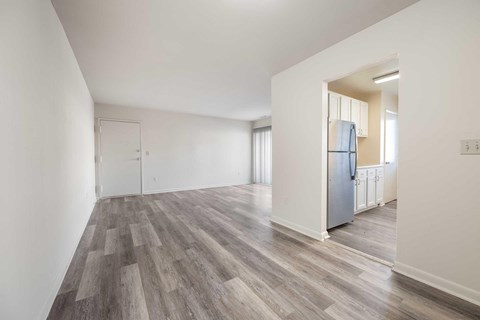 an empty living room with a refrigerator in it