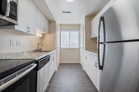 a kitchen with stainless steel appliances and white cabinets