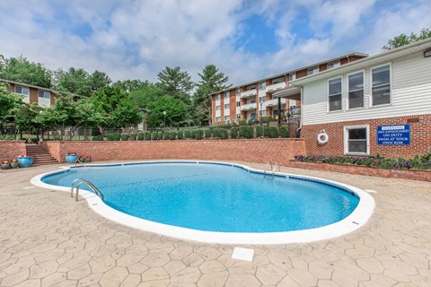 a resort style pool is in front of an apartment building