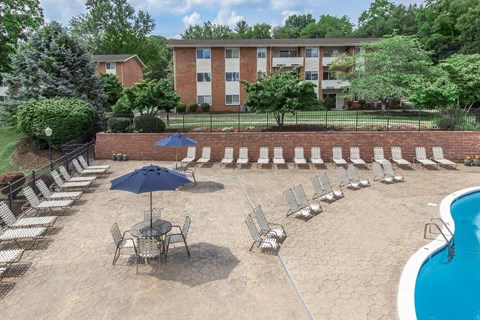 an aerial view of an outdoor pool with chairs and umbrellas