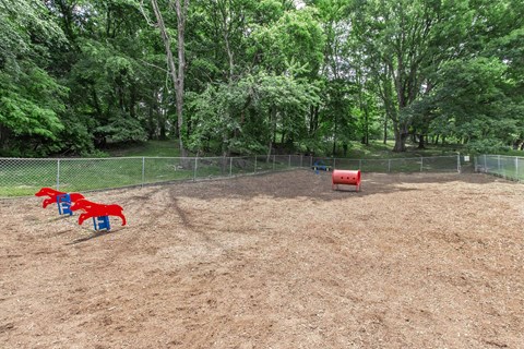 a playground with red and blue chairs in a park