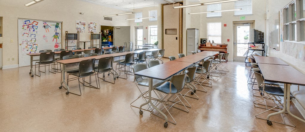 a large classroom with desks and chairs in a school building