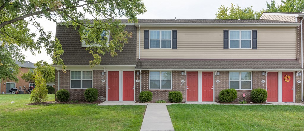 a home with red doors and a sidewalk in front of it