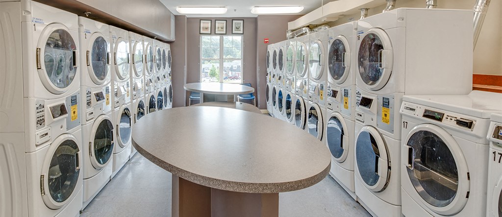 a washer and dryer area in a laundry room with many washing machines