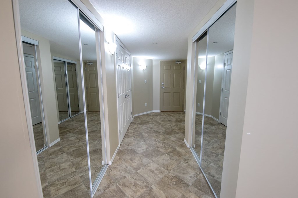 a walk in closet with mirrored doors in a room