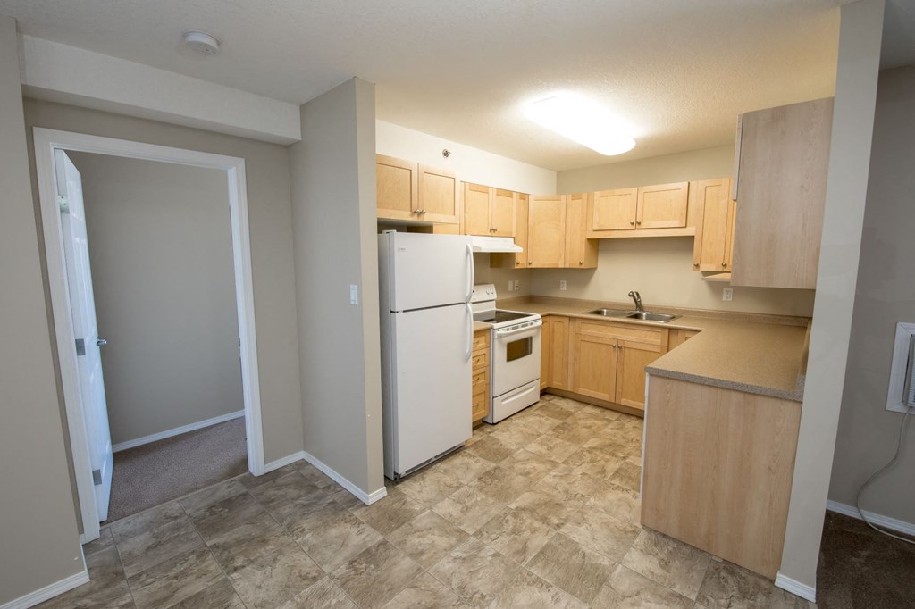 a kitchen with wooden cabinets and a white refrigerator