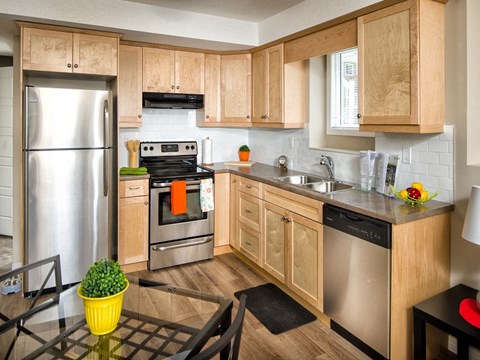 a kitchen with wooden cabinets and stainless steel appliances