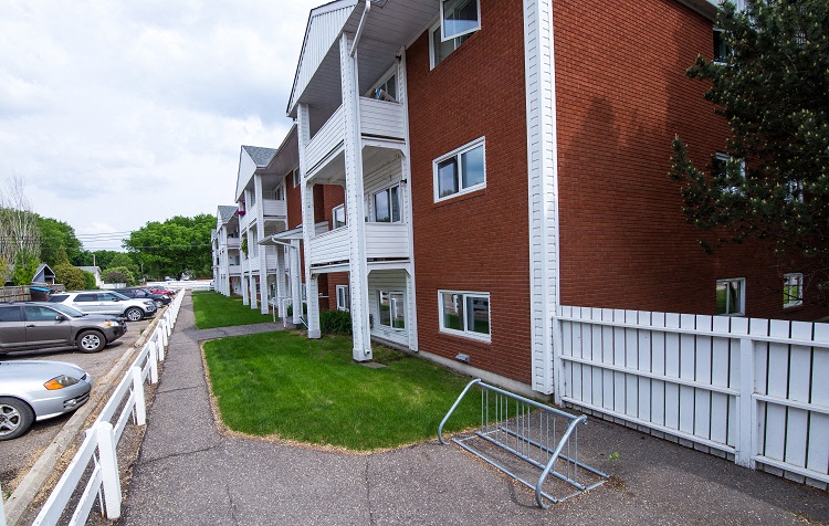 a row of houses with cars parked in front of them