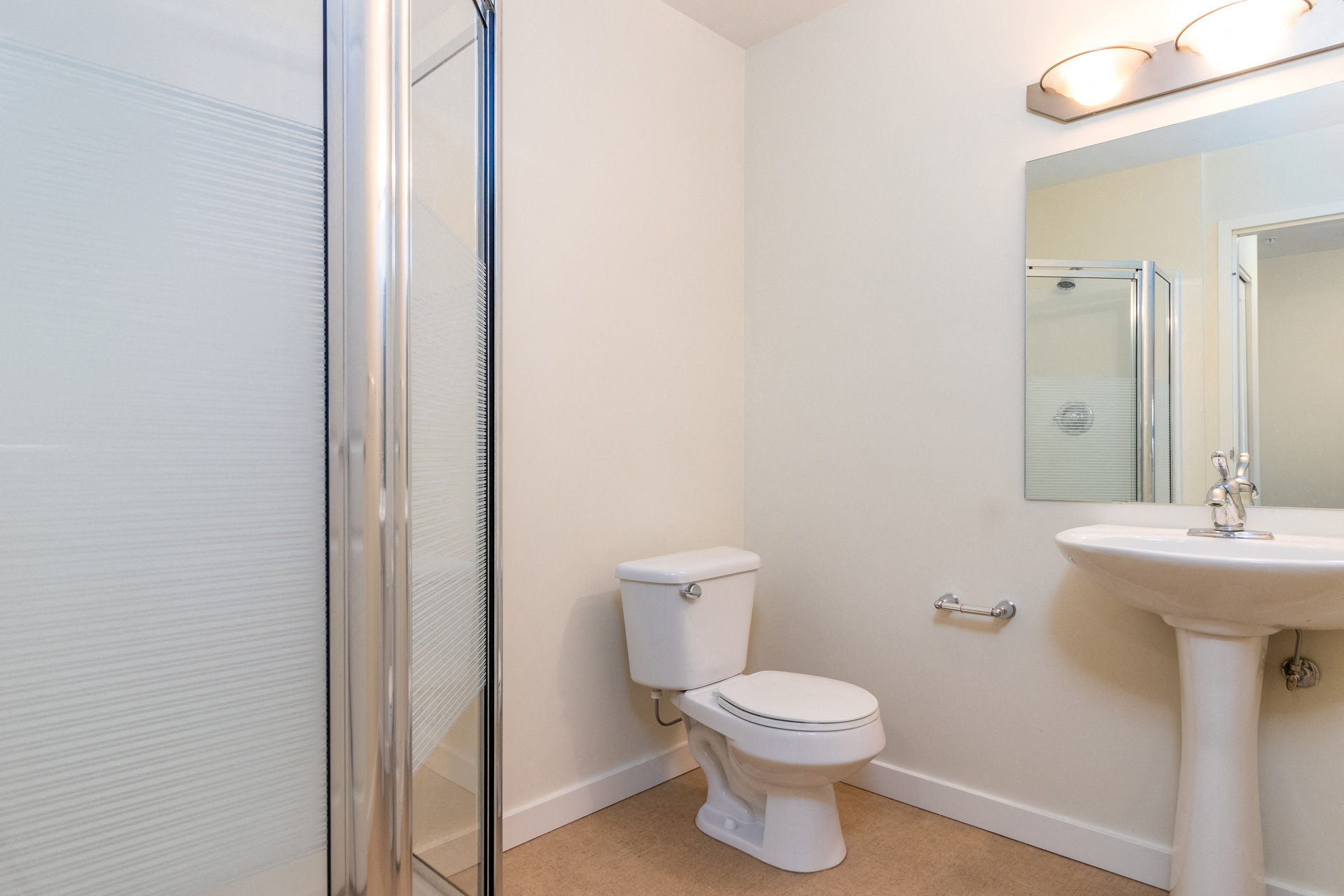 a bathroom with a shower and a toilet and a sink