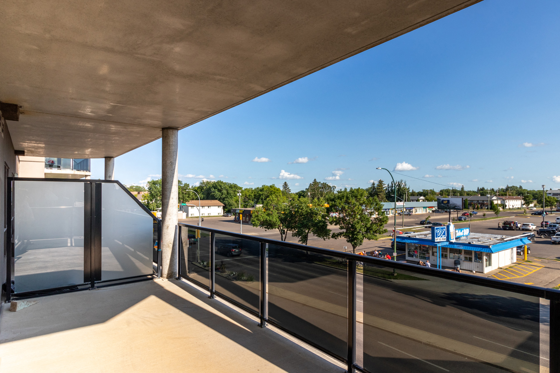 a balcony with a view of a parking lot and a blue sky