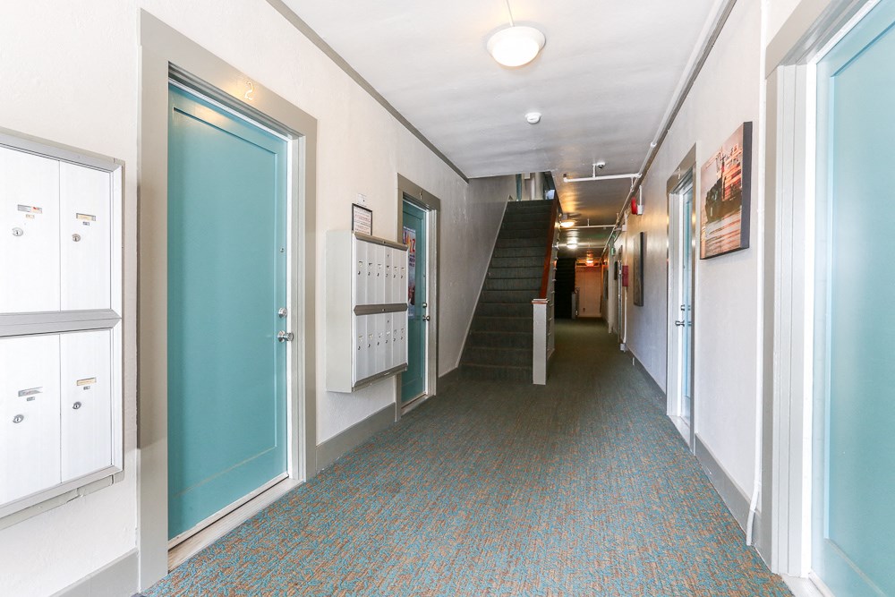 a hallway with doors and stairs in a building