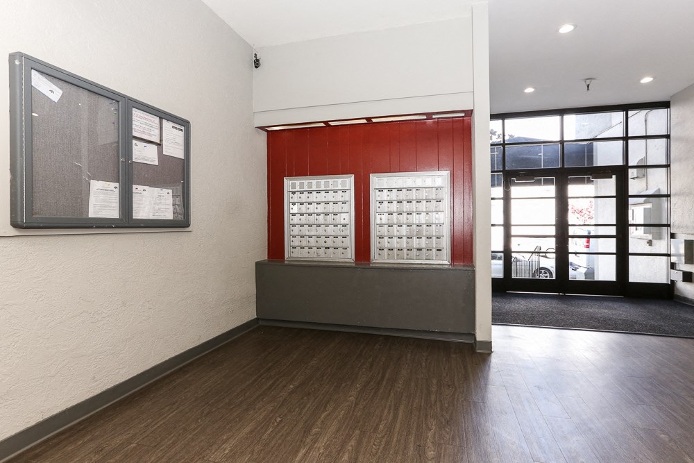 the lobby of a building with a red wall and a glass door