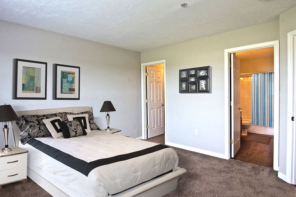 a bedroom with a bed and a door to a bathroom