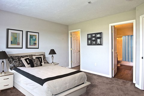 a bedroom with a bed and a door to a bathroom