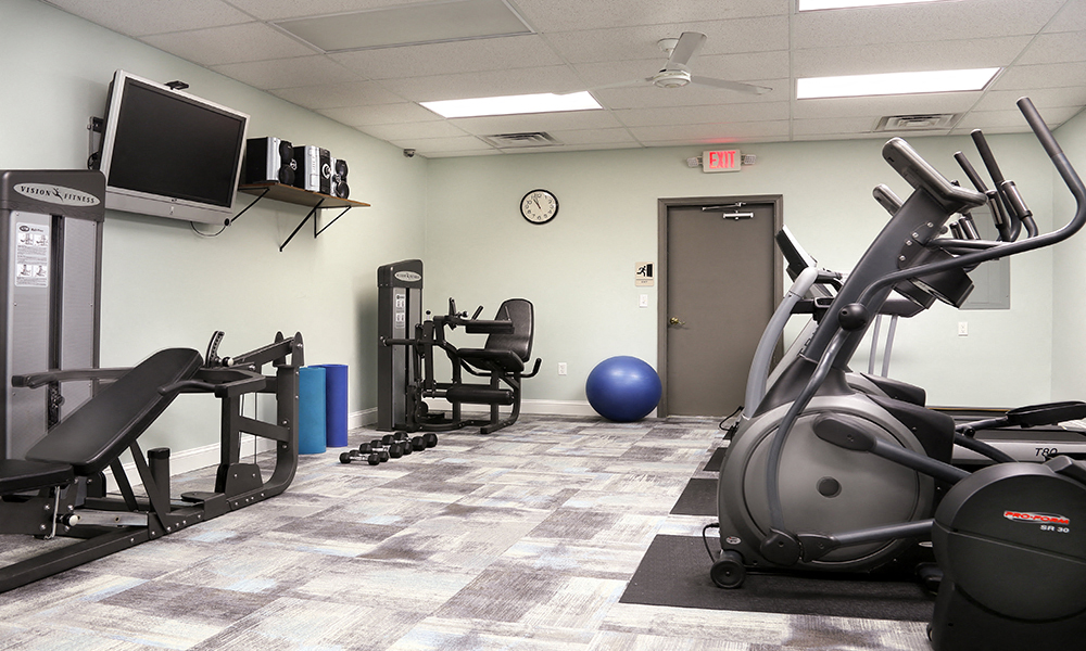 a gym with exercise equipment and a tv