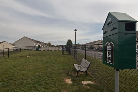 a park bench sitting in front of a fence