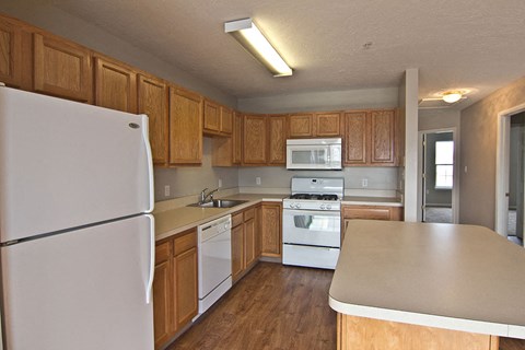 a kitchen with white appliances and wooden cabinets