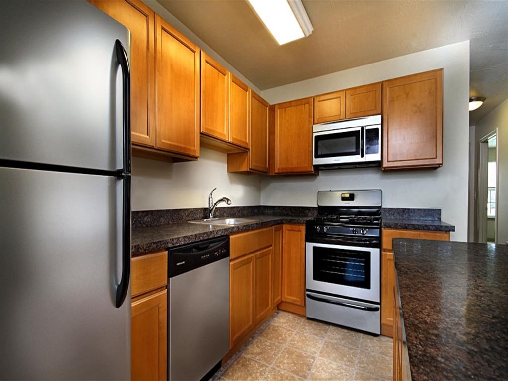 a kitchen with stainless steel appliances and wooden cabinets
