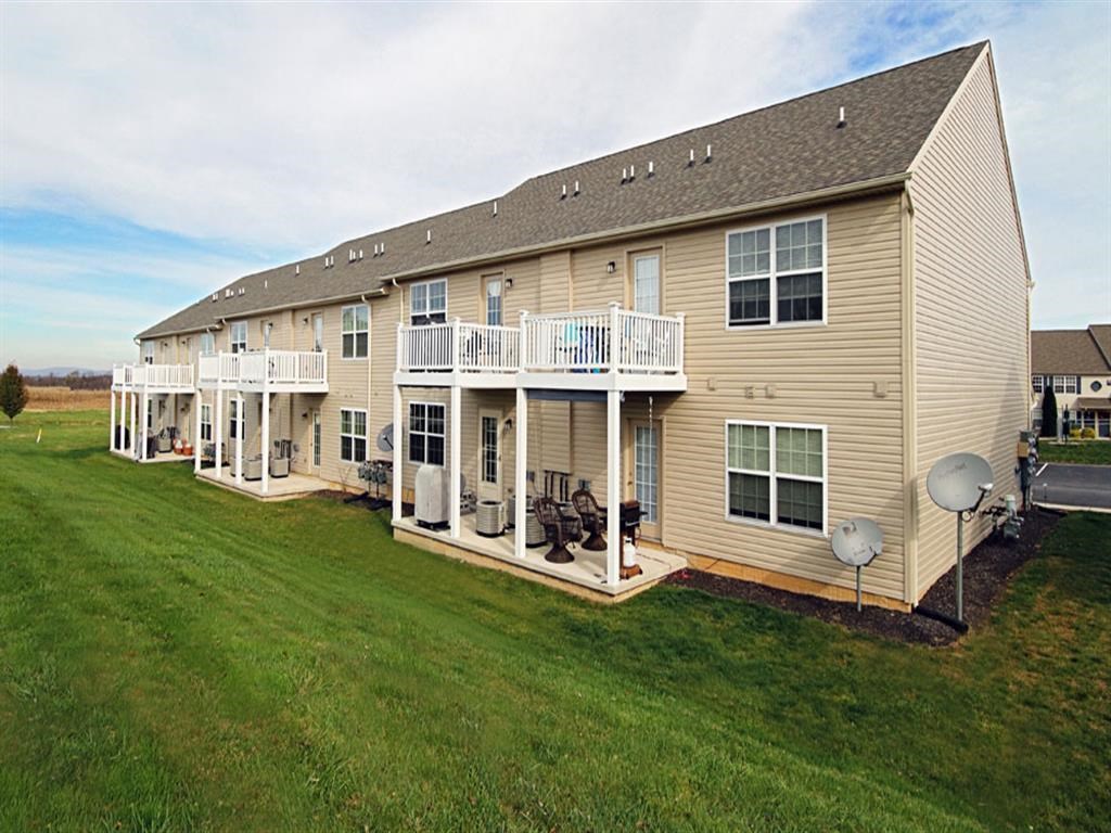 the back of a house with a porch and a yard