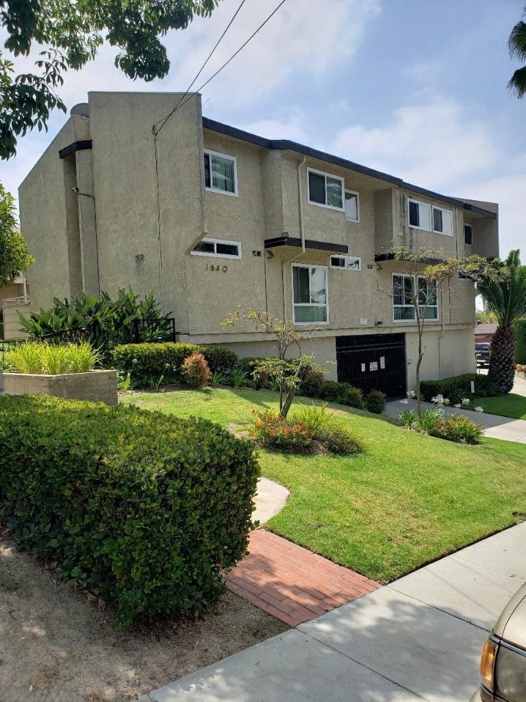 a house with a lawn and bushes in front of it