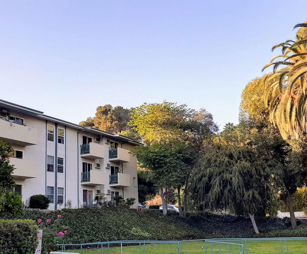 the apartment building has a tennis court in front of it
