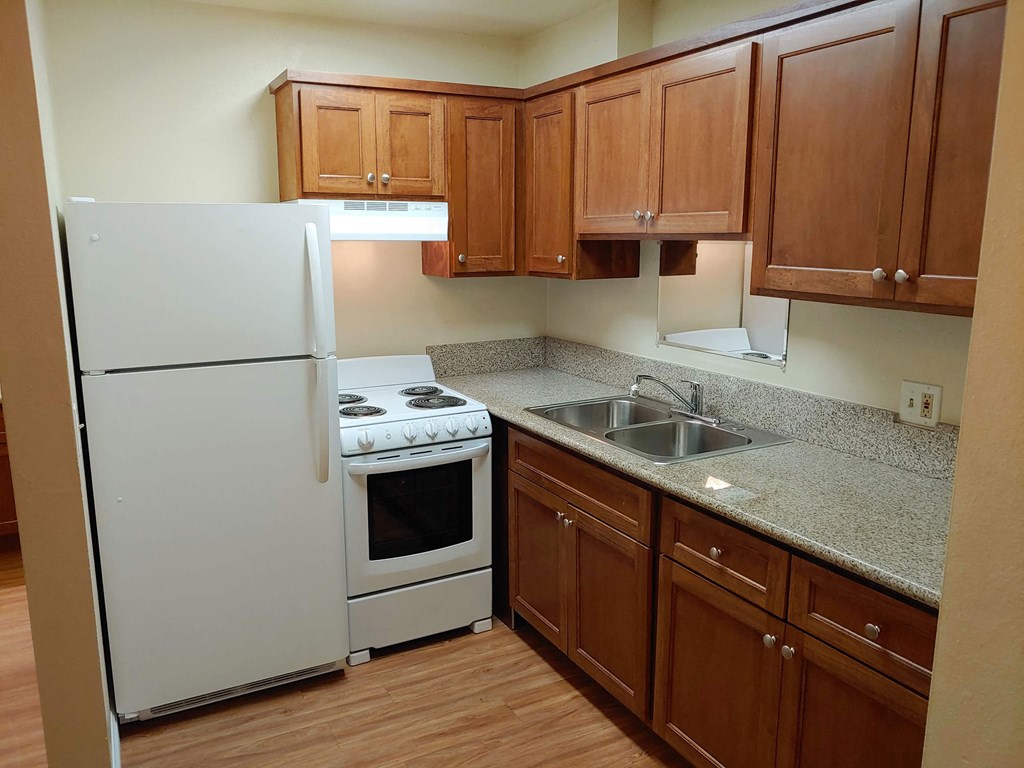 a kitchen with white appliances and wooden cabinets