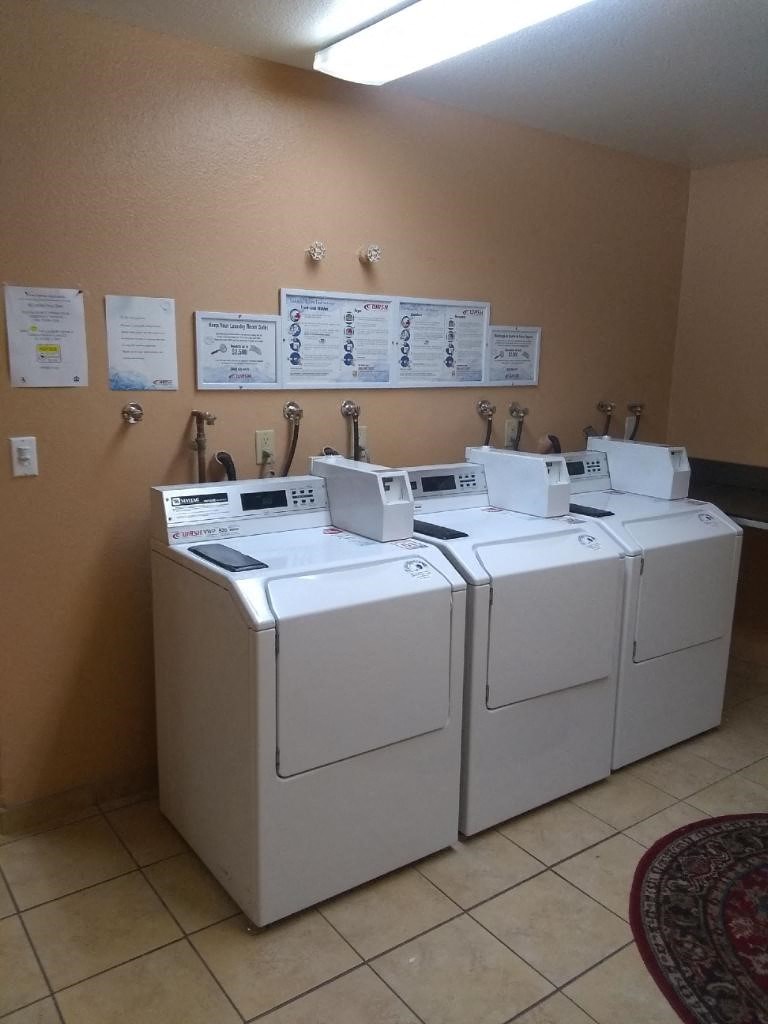 four washing machines in a room with signs on the wall