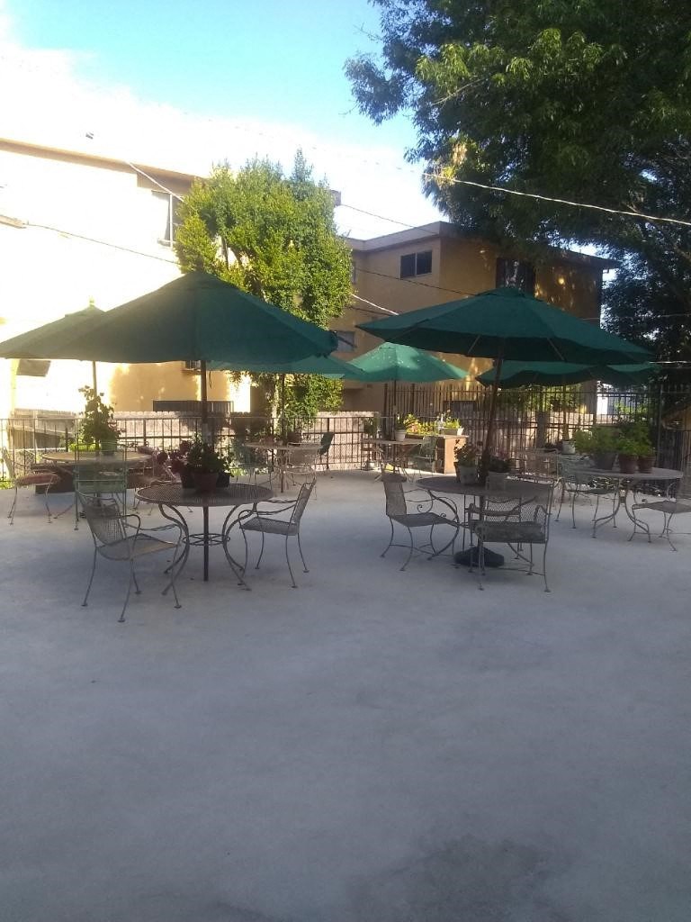an outdoor patio with tables and chairs and umbrellas