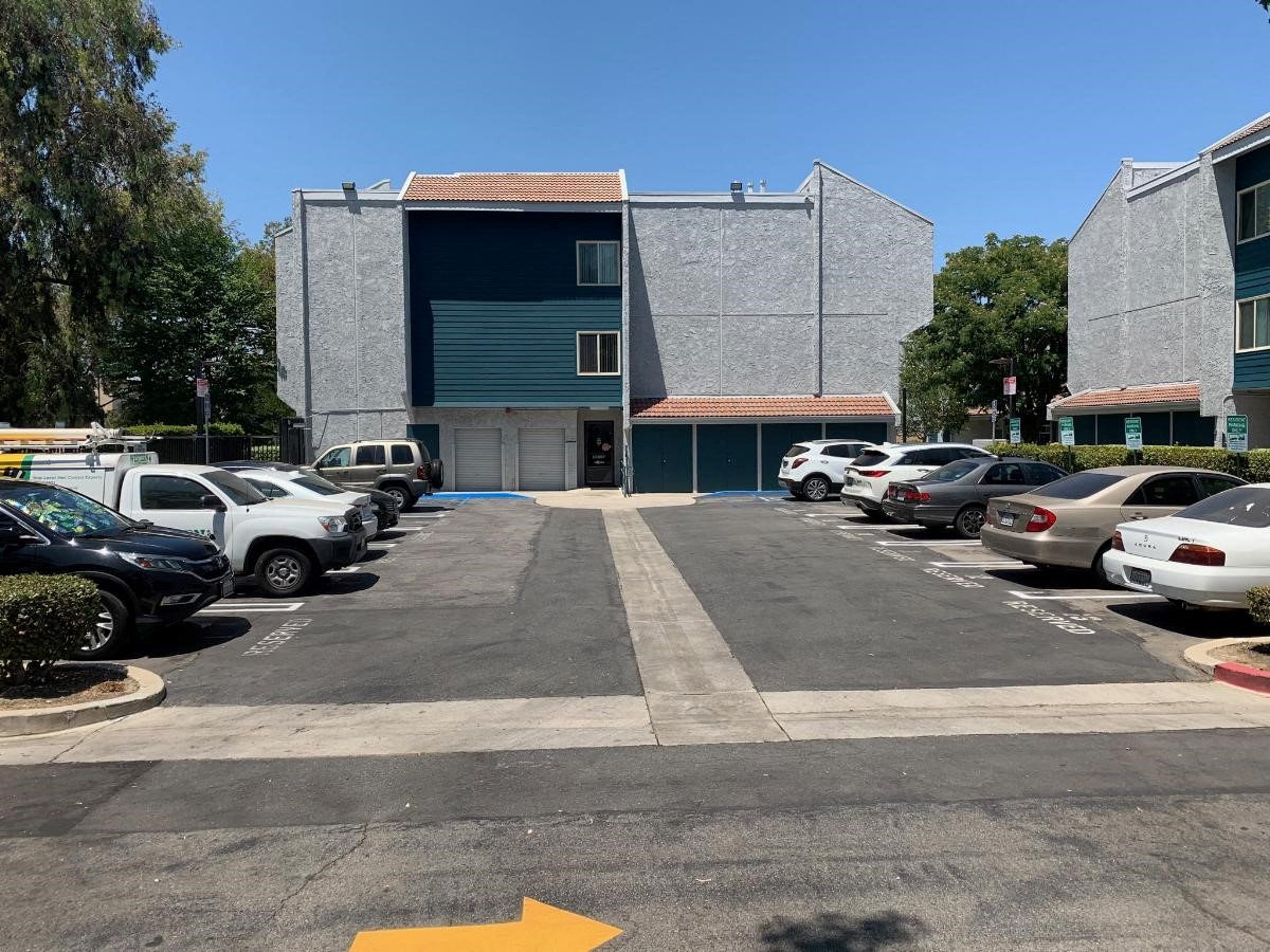 a parking lot full of cars in front of a building