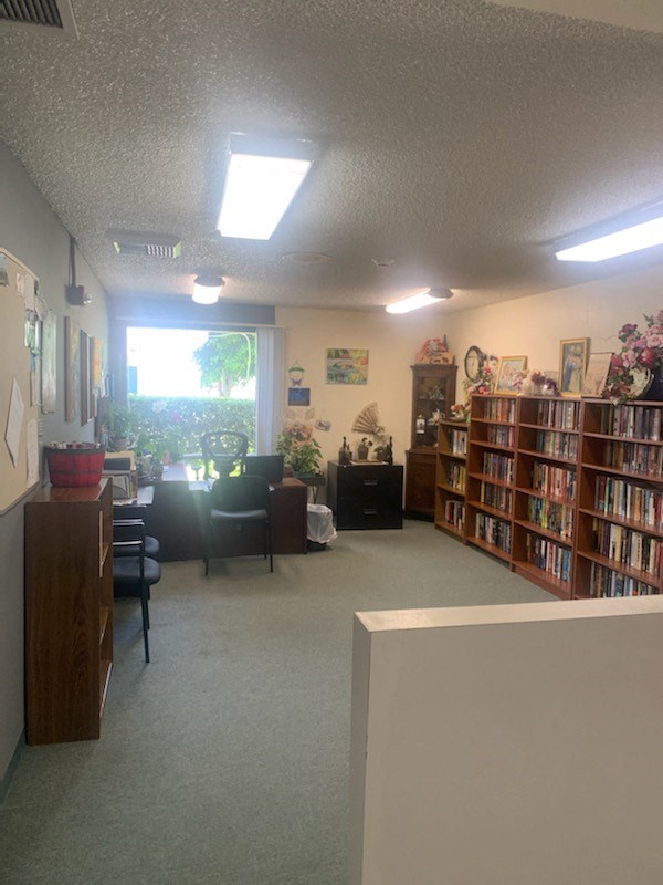 a library with stacks of books and a table with chairs