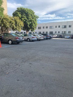 a parking lot filled with cars in front of a building