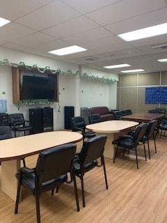 a conference room with tables and chairs and a tv