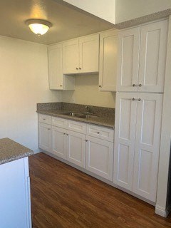a white kitchen with a sink and white cabinets