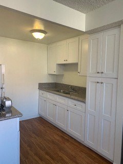 a white kitchen with white cabinets and a sink