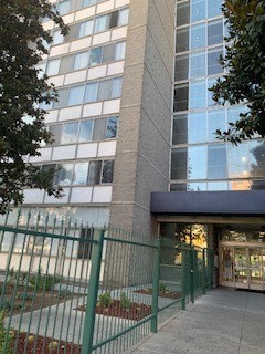 a tall building with a green fence in front of it