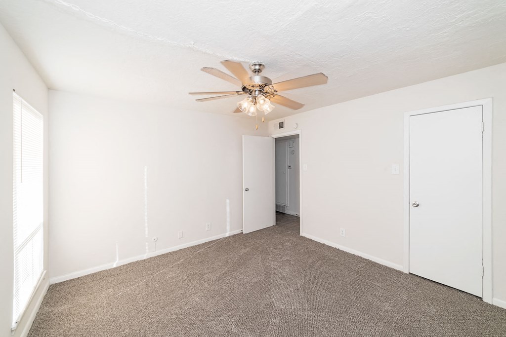 a living room with carpet and a ceiling fan