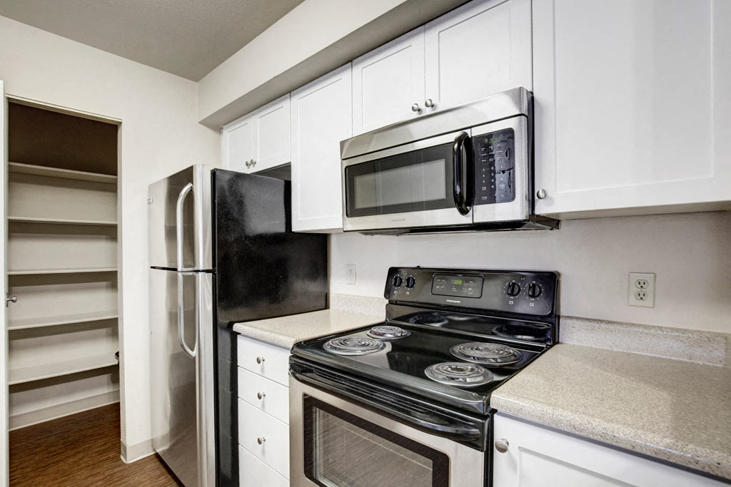 a kitchen with stainless steel appliances and white cabinets