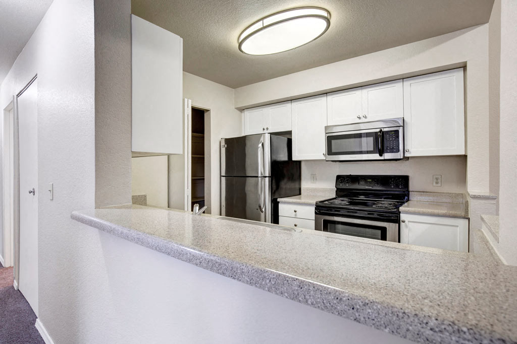 a kitchen with white cabinets and a counter top