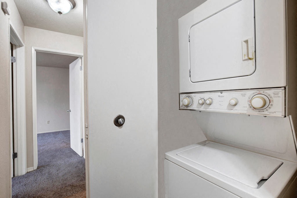 a white washer and dryer in a room with a white door