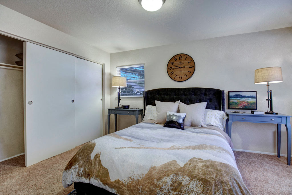 a bedroom with a bed and a clock on the wall
