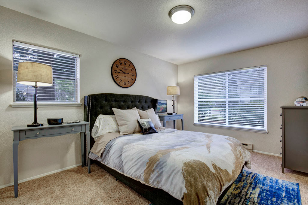 a bedroom with a bed and a clock on the wall