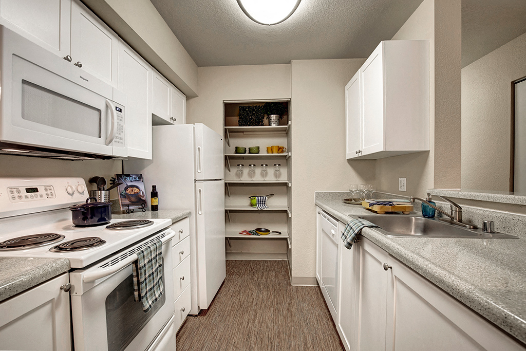 a kitchen with white appliances and counter tops